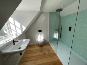 wooden floor bathroom with glass shower by Bathroom Inspirations